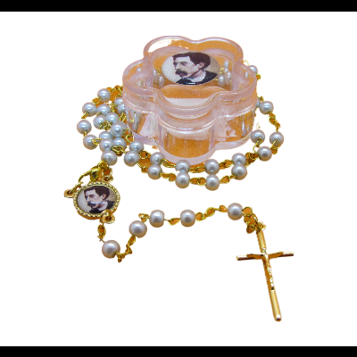 Terço com contas peroladas, corrente dourada, crucifixo e medalha com imagem, sobre caixa plástica em forma de flor