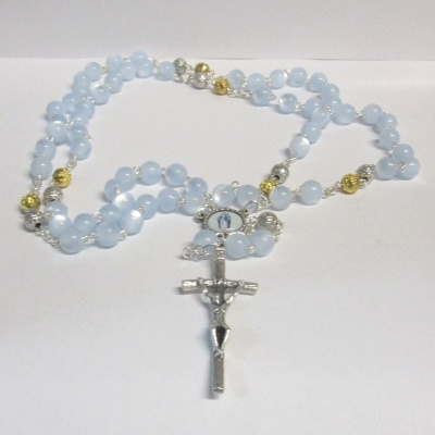 Terço azul com cruz prateada e contas douradas e transparentes
