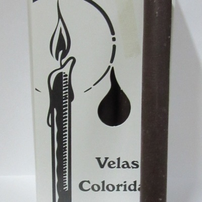 Vela marrom escura com caixa branca de velas coloridas