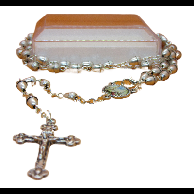 Rosário com crucifixo metálico e contas tipo pérola sobre caixa rosa clara.