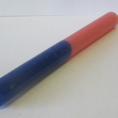 Vela bicolor azul e vermelha em superfície branca