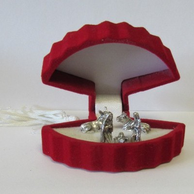 Estojo vermelho em veludo com presépio metálico prateado no interior branco