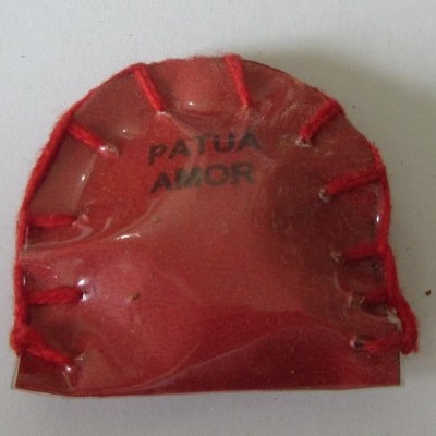Figura vermelha translúcida semicircular com costura e texto 'PATUA AMOR'