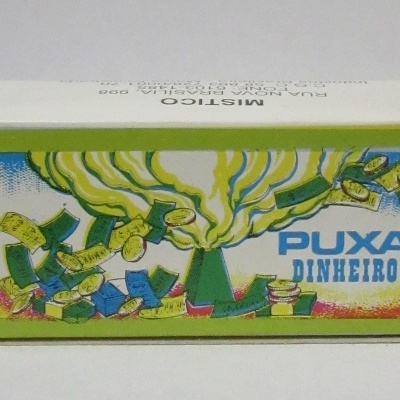 Caixa branca com rótulo colorido e texto 'PUXA DINHEIRO'.
