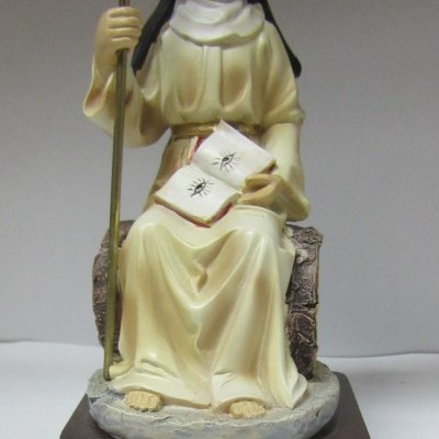 Estátua de Santa Mónica com túnica creme e manto preto segurando um livro e um cajado