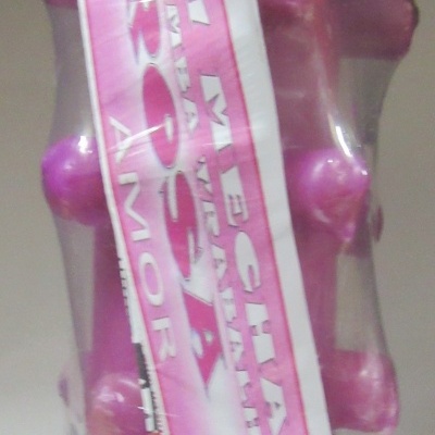 Massageador rosa de plástico com etiquetas visíveis e embalagem transparente
