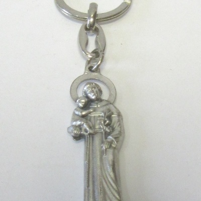 Chaveiro prateado com figura de santo e criança