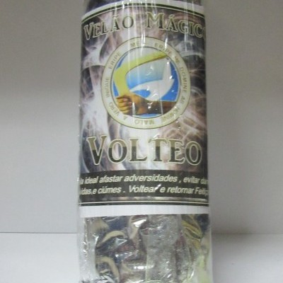 Vela embalada com rótulo preto e prateado com texto 'VELA MÁGICA VOLTEO'