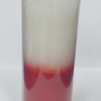 Vela bicolor branca e rosa em copo de vidro transparente