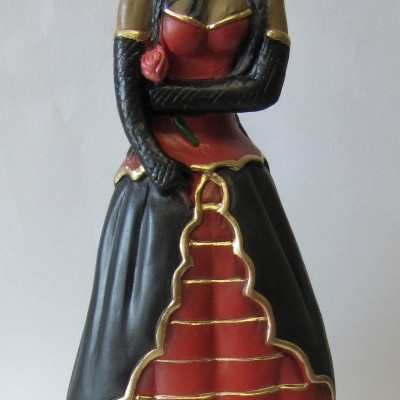 Estátua de figura feminina em vestido vermelho e preto com base escrita POMBA GIRA DO CABARÉ