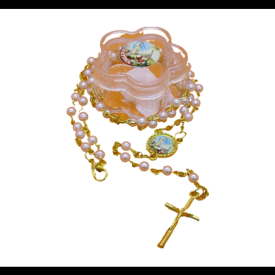 Terço com contas cor de pérola e crucifixo dourado junto a caixa rosa em forma de flor com imagem religiosa