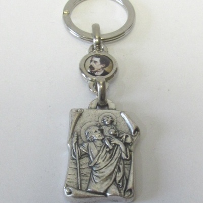 Chaveiro metálico prateado com figuras religiosas gravadas