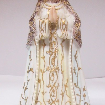 Estátua de Nossa Senhora com manto branco e dourado, coroada, sobre base castanha