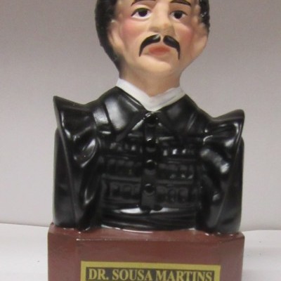 Busto cerâmico de homem com roupa preta e base com etiqueta DR. SOUSA MARTINS