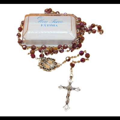 Terço com contas castanhas e crucifixo dourado sobre caixa branca com texto azul.