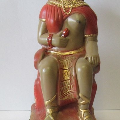 Estátua decorativa de figura sentada com roupa vermelha e detalhes dourados