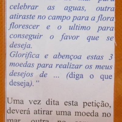 Embalagem com duas moedas douradas e texto em português sobre moedas de Santa Helena.