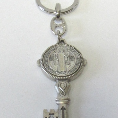 Chaveiro metálico prateado em forma de chave antiga com medalhão redondo gravado