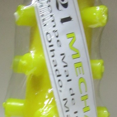 Peça amarela de plástico com saliências e etiqueta embrulhada em película