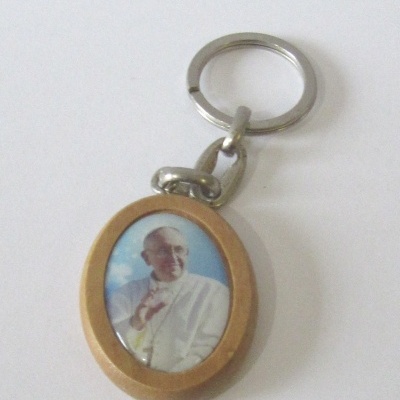 Porta-chaves oval com imagem colorida de figura religiosa em fundo azul