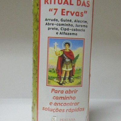 Vela de ritual amarela com ervas embutidas e rótulo com texto e imagem de santo.