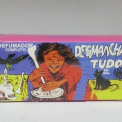 Caixa colorida de defumador com ilustração e texto DESMANCHA TUDO DE MAL