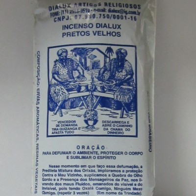 Pacote branco de plástico com texto azul e ilustração de duas figuras sentadas, contendo incenso Dialux Pretos Velhos.