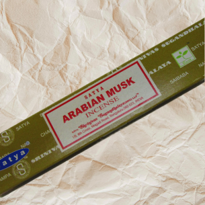 Embalagem verde de incenso Satya Arabian Musk sobre fundo de papel amassado