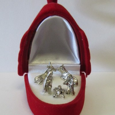 Miniatura de presépio em metal prateado numa caixa vermelha de veludo