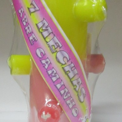 Objeto plástico amarelo e rosa com etiqueta '7 MECHAS ABRE CAMINHO'