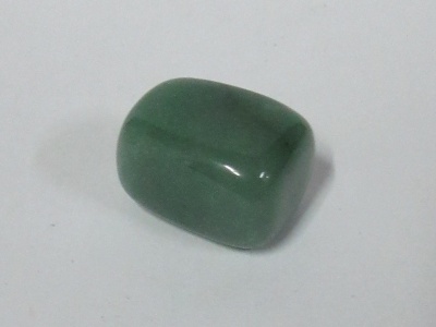 Pedra polida verde sobre superfície branca