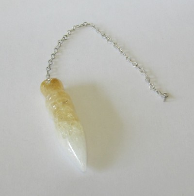 Pêndulo de pedra amarelo e branco com corrente metálica prateada sobre fundo branco