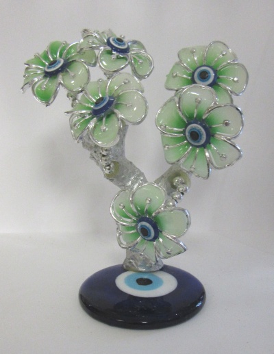 Escultura de flores verdes com olhos turcos e base azul