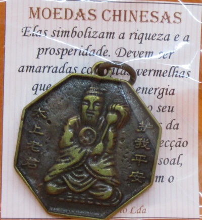 Pendente octogonal de metal com figura gravada e texto em português ao fundo
