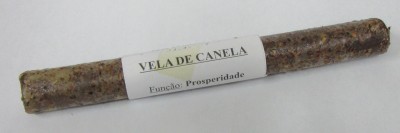Vela de canela cilíndrica com etiqueta branca sobre superfície clara