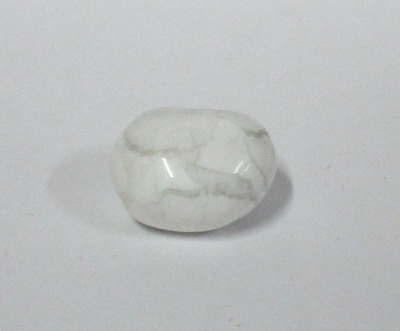 Pedra polida branca com veios cinzentos arredondada sobre fundo branco