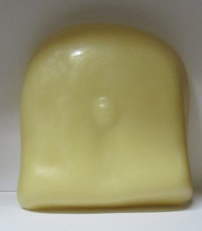 Pedaço de alimento sólido amarelo claro com formato arredondado