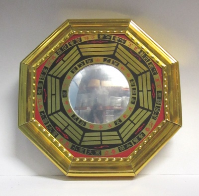 Espelho redondo com moldura octogonal dourada com símbolos chineses