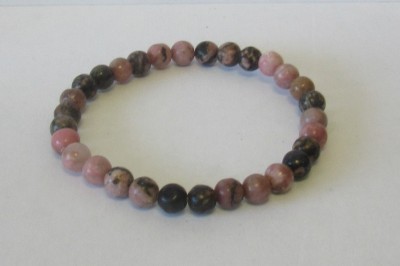 Pulseira de contas rosas e pretas sobre fundo branco.