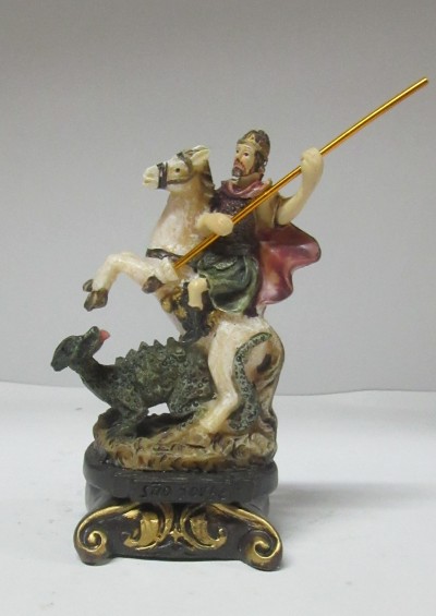 Figurinha de cavaleiro a cavalo com lança a combater um dragão sobre base decorativa