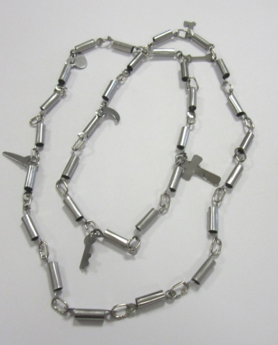 Colar metálico prateado com pingentes variados sobre fundo branco