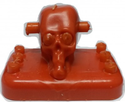 Peça de jogo plástica laranja com cabeça de robô/crânio numa base retangular.