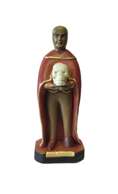 Estátua de João Caveira segurando caveira com capa vermelha e base preta.