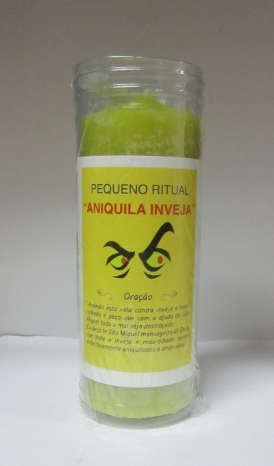 Vela verde em copo de vidro com etiqueta de ritual contra inveja.