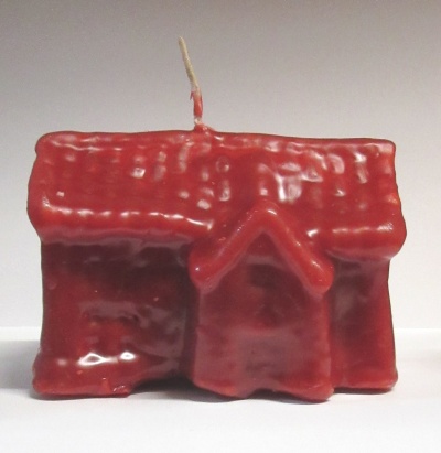 Vela vermelha em forma de casa com telhado texturizado