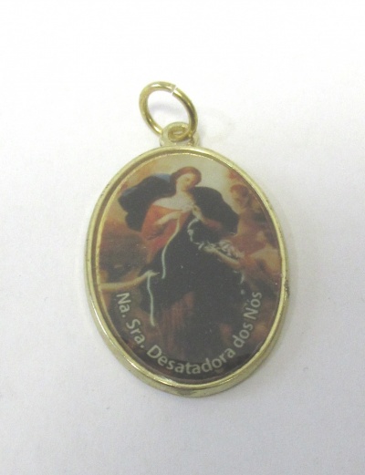 Medalha oval dourada com imagem religiosa de Santa Maria a desatar nós