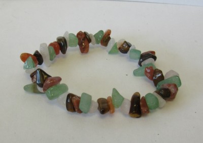 Pulseira de pedras coloridas em fio elástico sobre fundo branco