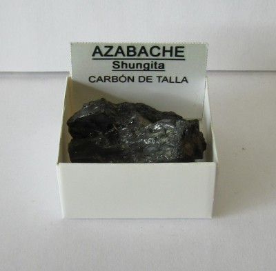 Pedra negra Shungita numa caixa branca com etiqueta