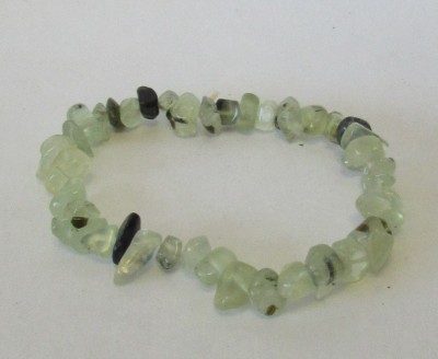 Pulseira de pedras verdes translúcidas com manchas escuras em superfície branca