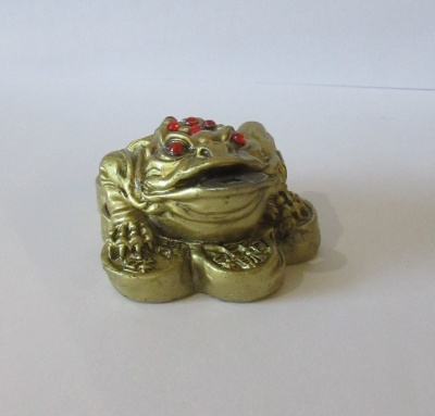 Estatueta de sapo dourado com olhos vermelhos